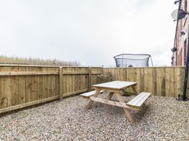 A garden with a picnic table and trampoline at East House-Sleeps 5-Pet friendly-Garden-Parking in Stakeford