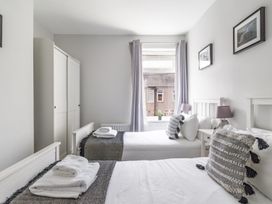 A bedroom with two beds and a wardrobe at East House-Sleeps 5-Pet friendly-Garden-Parking in Stakeford