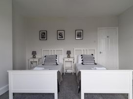A bedroom with two beds and bedside tables at East House-Sleeps 5-Pet friendly-Garden-Parking in Stakeford