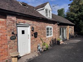 An outdoor view of a cottage with a brick wall and a front door at Cottage - Sleeps 4 - Parking Evesham