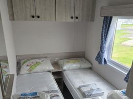 A bedroom with two single beds and a wardrobe at 3 Bedroom Cabin Sleeps 6 - Shared Pool & Shared Hot Tub near Flamingo Land Resort near Malton