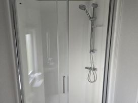 A shower with a showerhead and a soap dish at 3 Bedroom Cabin Sleeps 6 - Shared Pool & Shared Hot Tub, Flamingo Land Resort near Malton