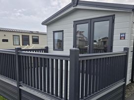 A cabin exterior with a deck at 3 Bedroom Cabin Sleeps 6 - Shared Pool & Shared Hot Tub, Flamingo Land Resort near Malton
