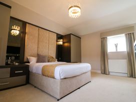 A bedroom with a bed and chandelier at Northumberland Luxury Stays - The Chivits West Chevington near Amble