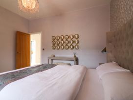 A bedroom with a bed and mirror on the wall at Northumberland Luxury Stays - The Chivits near West Chevington