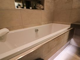 A bathroom with a bathtub and towel at Northumberland Luxury Stays - The Chivits near Amble