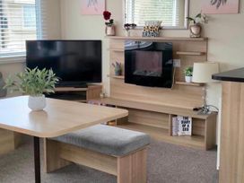 A living room with a television and a coffee table at Port Haverigg Cabin Sleeps 4 Steel Green near Haverigg