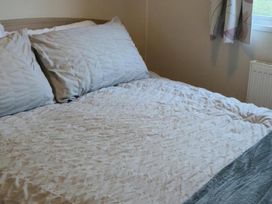 A bed with pillows and a bedspread at Port Haverigg Cabin Sleeps 4 Steel Green near Haverigg
