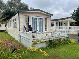 A lodge with a deck and chairs at 2 Bed Lodge Sleeps 5 - Pet Friendly, WiFi, Parking, Skegness