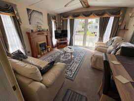 A living room with a sofa and a television at 2 Bed Lodge Sleeps 5 - Pet Friendly, WiFi, Parking in Skegness