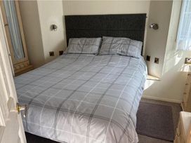 A bedroom with a bed and wardrobe at 2 Bed Lodge Sleeps 5 - Pet Friendly, WiFi, Parking Skegness