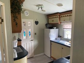 A kitchen with a fridge, sink, and cupboard at 2 Bed Lodge Sleeps 5 - Pet Friendly, WiFi, Parking, Skegness