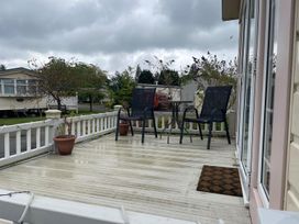 A outdoor patio with two chairs and a table at 2 Bed Lodge Sleeps 5 - Pet Friendly, WiFi, Parking in Skegness