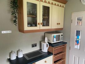 A kitchen with cabinets, microwave, kettle and containers at 2 Bed Lodge Sleeps 5 - Pet Friendly, WiFi, Parking Skegness