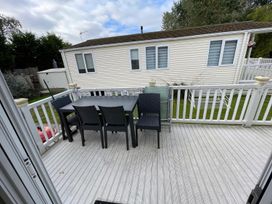 An outdoor seating area with a table and chairs at 2 Bed Lodge Sleeps 5 - Pet Friendly, WiFi, Parking, Skegness