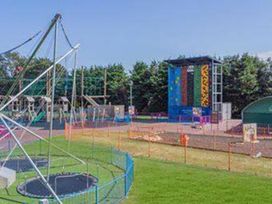 An outdoor play area with climbing wall and trampoline at a park in Skegness