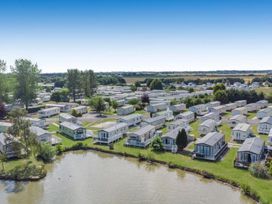 An overview of a caravan park with a pond at 2 Bed Lodge Sleeps 5 - Pet Friendly, WiFi, Parking, Skegness