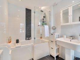 A bathroom featuring a bath, shower, sink, and cabinet at 1 Bed - Sleeps 4 - Parking - Pets - Town Centre Wadebridge
