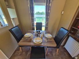 A dining room with a table set for meals at Cabin - Sleeps 6 - Outdoor Pool and Parking, Cenarth