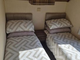 A bedroom with two beds and a nightstand at Cabin - Sleeps 6 - Outdoor Pool and Parking in Cenarth