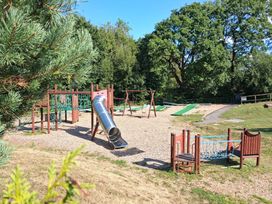 A playground with a slide and swings at a park in Cenarth