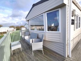 An outdoor seating area with chairs and a table at Snowdonia Sunbeach Holiday Sea and Mountain view, Llwyngwril
