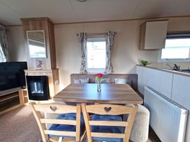 A living room with a table and chairs at Snowdonia Sunbeach Holiday Sea and Mountain view in Llwyngwril