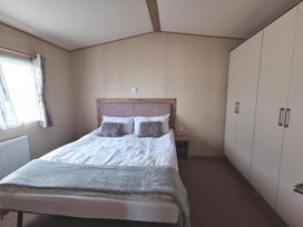 A bedroom with a bed and wardrobe at Snowdonia Sunbeach Holiday Sea and Mountain view in Llwyngwril