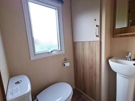 A bathroom with a toilet and sink at Snowdonia Sunbeach Holiday Sea and Mountain view, Llwyngwril