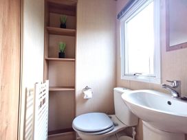 A bathroom with a toilet and sink at Snowdonia Sunbeach Holiday Sea and Mountain view, Llwyngwril