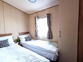 A bedroom with beds and a window at Snowdonia Sunbeach Holiday Sea and Mountain view in Llwyngwril