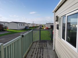 A view from a deck showing mobile homes and a road at Snowdonia Sunbeach Holiday Sea and Mountain view Llwyngwril
