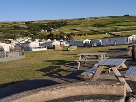 An outdoor area with picnic tables and caravans at Snowdonia Sunbeach Holiday Sea and Mountain view Llwyngwril