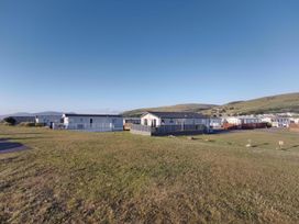 A view of mobile homes in a grassy area at Snowdonia Sunbeach Holiday Sea and Mountain view, Llwyngwril