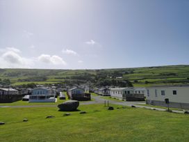 A view of caravans with hills in the background at Snowdonia Sunbeach Holiday Sea and Mountain view Llwyngwril