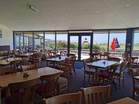 A dining room with tables and chairs at Snowdonia Sunbeach Holiday Sea and Mountain view in Llwyngwril
