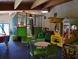 A play area with arcade machines and dining tables at Snowdonia Sunbeach Holiday Sea and Mountain view, Llwyngwril