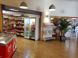 A shop interior with shelves of products and a refrigerator at Snowdonia Sunbeach Holiday Sea and Mountain view, Llwyngwril