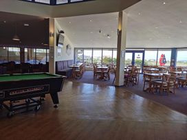 A dining area with a pool table and tables at Snowdonia Sunbeach Holiday Sea and Mountain view in Llwyngwril