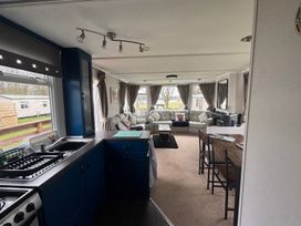 A kitchen and living room area at No 38 Heilan Hoose at Three Lochs Holiday Park near Newton Stewart
