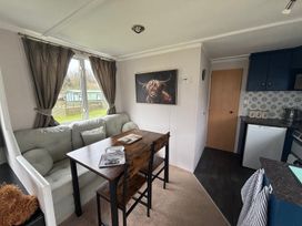 A dining room with a table and chairs at No 38 Heilan Hoose at Three Lochs Newton Stewart