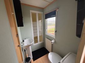 A bathroom with a sink, shower, and toilet at No 38 Heilan Hoose at Three Lochs Newton Stewart