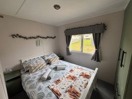 A bedroom with a bed and bedside table at No 38 Heilan Hoose at Three Lochs Newton Stewart