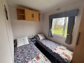 A bedroom with two single beds and a window at No 38 Heilan Hoose at Three Lochs Newton Stewart