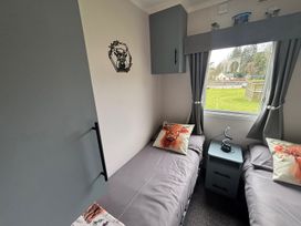 A bedroom with two beds and a lamp at No 38 Heilan Hoose at Three Lochs Newton Stewart