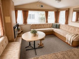 A living room with a sofa and table at Seaside Tranquility Retreat in Clacton