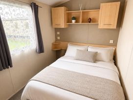 A bedroom with a bed and shelves at Seaside Tranquility Retreat in Clacton