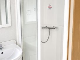 A bathroom with a shower and a sink at Seaside Tranquility Retreat in Clacton