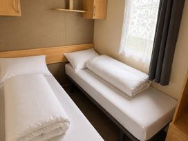 A bedroom with two beds and a window at Seaside Tranquility Retreat in Clacton