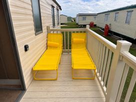 An outdoor deck with yellow lounge chairs at Seaside Tranquility Retreat in Clacton
